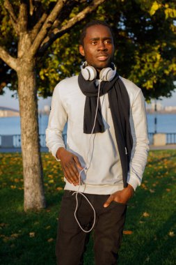 Parktaki kulaklıklı Afrikalı adam.