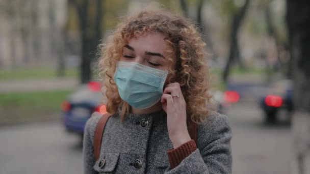 Vrouw neemt het beschermend masker af en lacht — Stockvideo