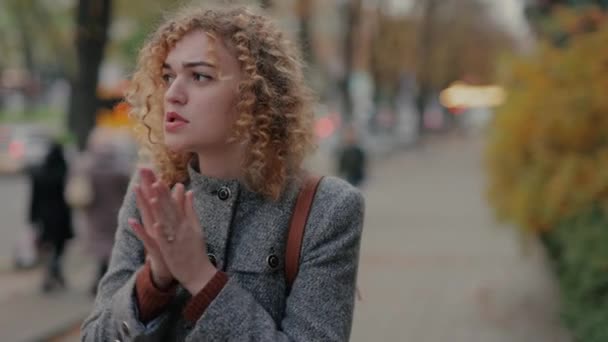 Vrouw is koud en verwarmt haar handen — Stockvideo