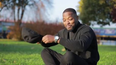 Afro-Amerikalı adam parka şapka koyar.