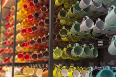 Alışveriş merkezinin raflarında çok renkli bardaklar asılı.