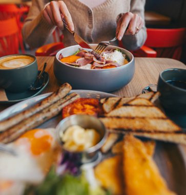 Kahvaltıyı çatal ve bıçakla yapan kadın.