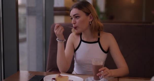 Mooie vrouw die dessert eet en koffie drinkt op het terras — Stockvideo