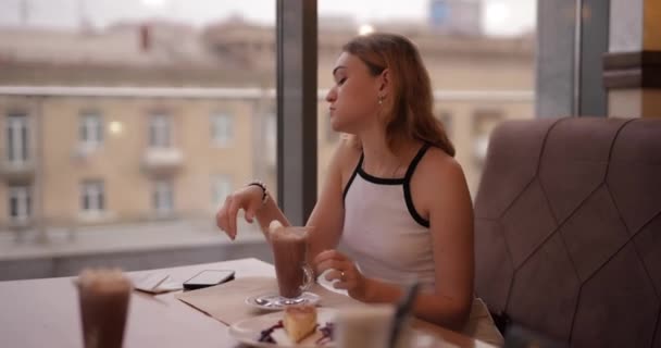 Mooie vrouw die dessert eet en koffie drinkt op het terras — Stockvideo