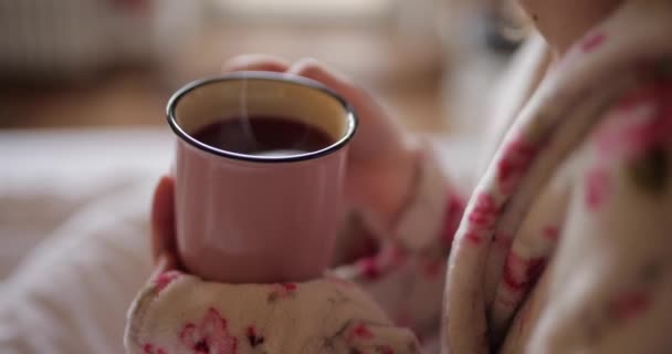 ผู้หญิงสาวดื่มชาจากถ้วยบนเตียง — วีดีโอสต็อก