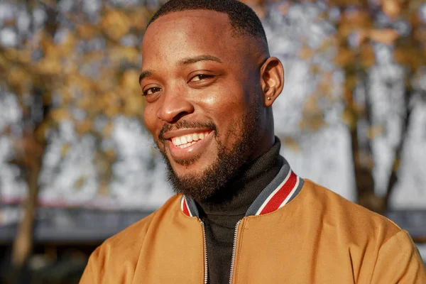 African-American man chatting in smartphone, outdoors