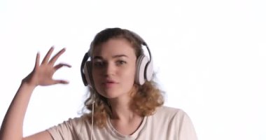 Kulaklıklı mutlu kadın müzik dinliyor ve arka planda dans ediyor.