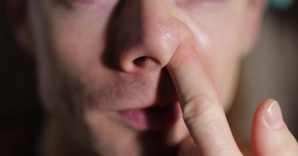 Un homme méconnaissable qui se pique le nez avec son doigt — Video