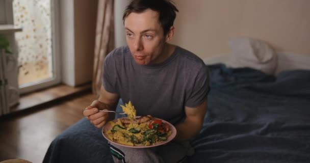 Orang makan pasta dan menonton tv di rumah — Stok Video