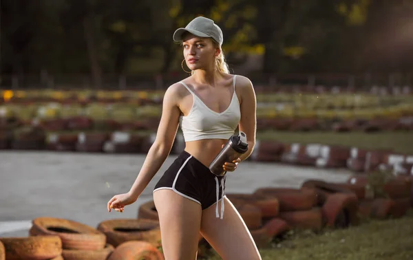 Sportliches Mädchen in Shorts und BH mit Shaker — Stockfoto