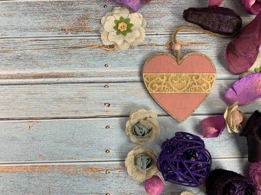 Kalpli, çiçekli ve dekorasyonlu romantik bir sahne. Eski ahşap bir arka planda, yazacak yeri olan.