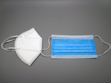 FFP2 ve cerrahi maske, gri arka planda.