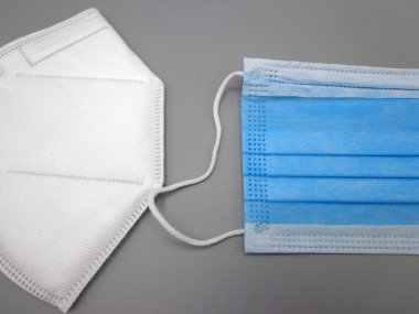 FFP2 ve cerrahi maske, gri arka planda.