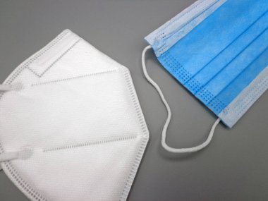 FFP2 ve cerrahi maske, gri arka planda.