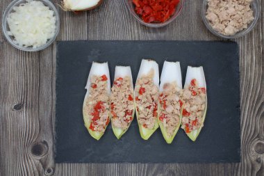 Ton balığı, kırmızı biber ve soğanla dolu hindibanlar yukarıdan görülüyor.