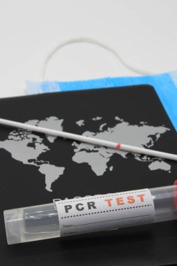 PCR testinin yanında maskeli bir pasaport 
