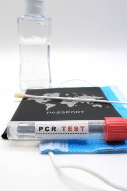 PCR testinin yanında maskeli bir pasaport 