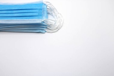 Beyaz arka planda cerrahi maskeler birikti.