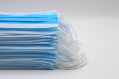 Beyaz arka planda cerrahi maskeler birikti.