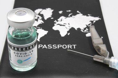 Pasaportun yanında şırınga ve aşı şişesi var.