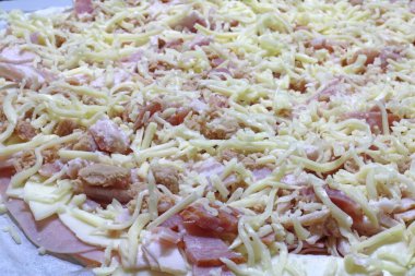 Pişirmeden önce ev yapımı pastırmalı pizza.