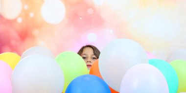 Renkli balonlarla dolu bir havuzdan çıkan bir kızın kafası.