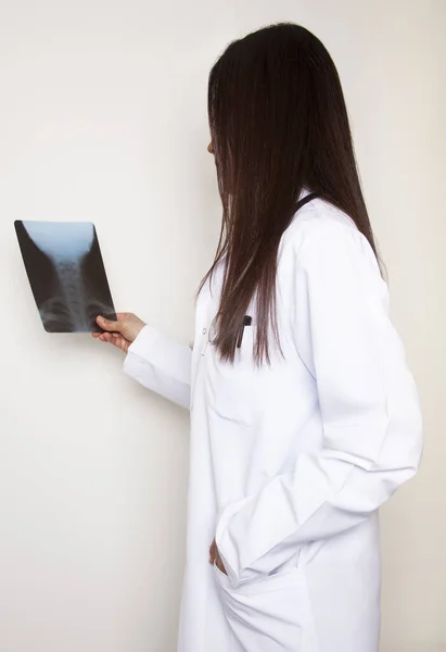 Female doctor examines the x-ray film. Examination room in hospital. Medicine and healthcare concept.