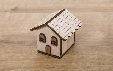 Emlakçı evi modeli. Tahtadan yapılmış küçük bir ev modeli. Emlak kavramı.