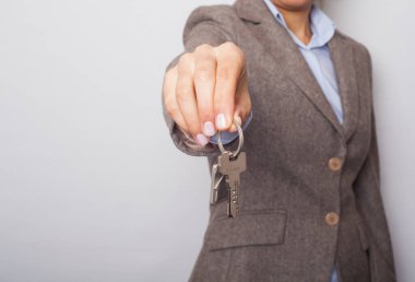 Genç bayan emlakçı evin anahtarını veriyor..