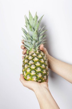 Olgun ananas kadın elinde, beyaz arka planda izole edilmiş.. 