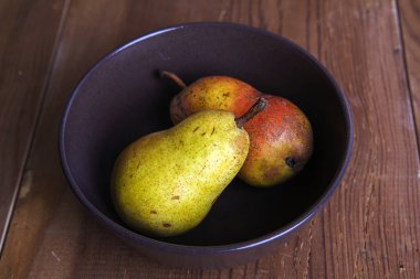 Tahta arka planda izole edilmiş güzel, taze, sarı bir armut..