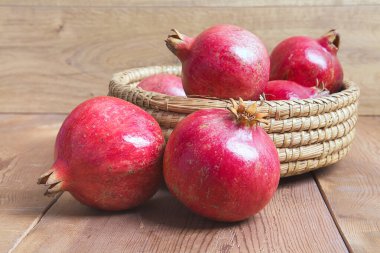 Biraz kırmızı sulu nar, bütün ve kırık, koyu kırsal ahşap masa üzerinde.