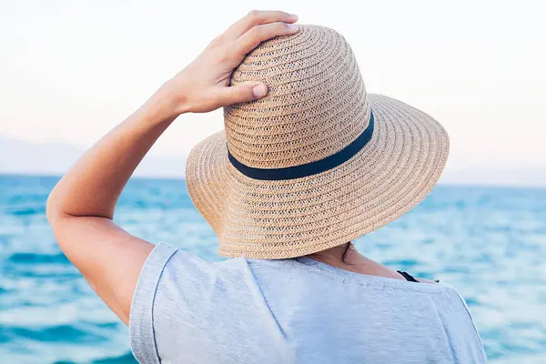 Yaz konseptiyle sahilde yürüyen bir kadın..