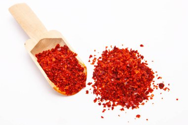 Ahşap kaşıkta kırmızı biber, beyaz arka planda kırmızı biber..