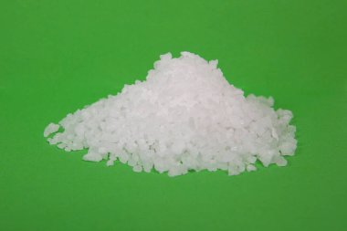 Yeşil zemin üzerinde kaba kaya veya deniz tuzu tanecikleri.