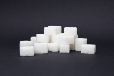 Siyah arkaplanda beyaz şeker küpü. 