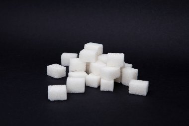 Siyah arkaplanda beyaz şeker küpü. 