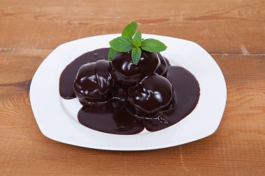 Üçlü Çikolatalı Profiterol. Beyaz tabakta tatlı.