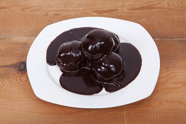 Üçlü Çikolatalı Profiterol. Beyaz tabakta tatlı.