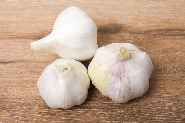 Ahşap arka planda tam sarımsak.