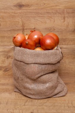 Tahta arka planda bir çuvalda soğan. Sağlıklı beslenme.