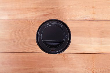  Tek kullanımlık kahve fincanı ahşap arka planda. 