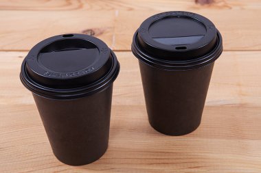  Tek kullanımlık kahve fincanı ahşap arka planda. 