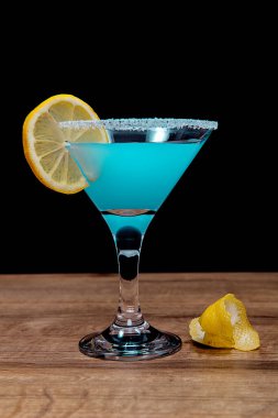  Siyah arka planda mavi alkollü içki.