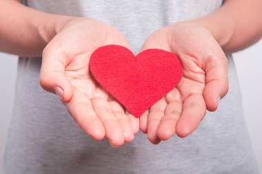  Kadının elinde kırmızı bir kalp var..