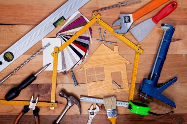 Ruh seviyesi, inşaat katı cetvel, ahşap masa arkasında onarım malzemeleri..