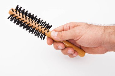 Adam elinde beyaz arka planda bir saç fırçası tutuyor..