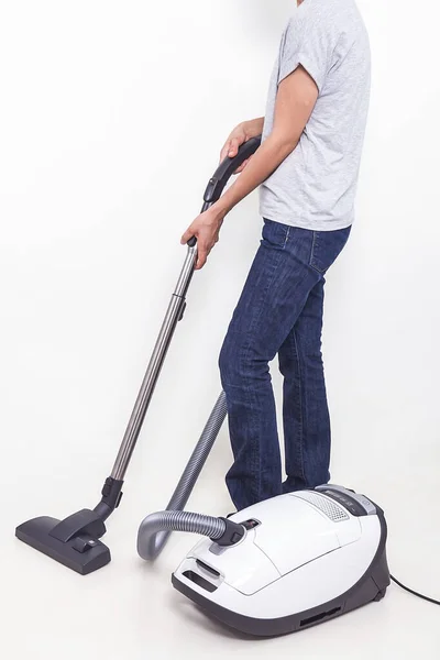 The woman is sweeping with a vacuum cleaner.