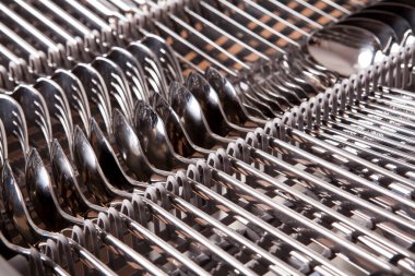 Bulaşık makinesinde yıkandıktan sonra çatallar, bıçaklar, kaşıklar, bardaklar ve tabaklar.