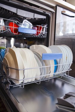Mutfakta temiz tabaklar olan bulaşık makinesini aç.